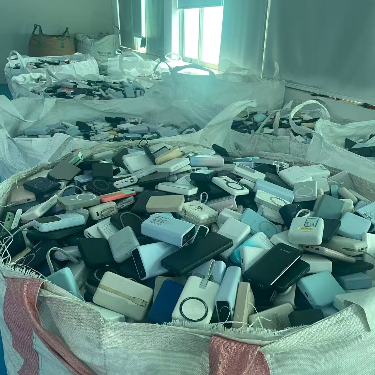 Multiple warehouse bags of used power banks in the stock room