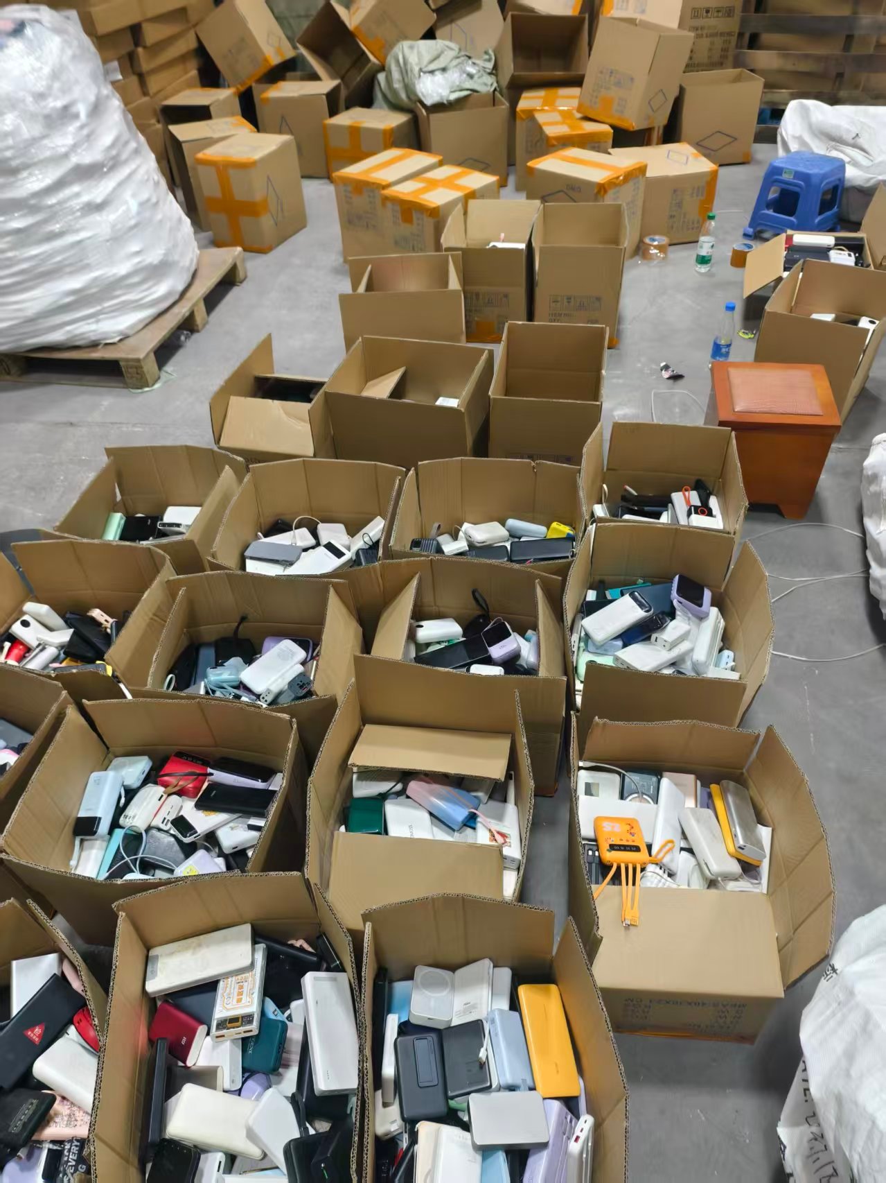 Used power banks sorted into cartons for batch checking