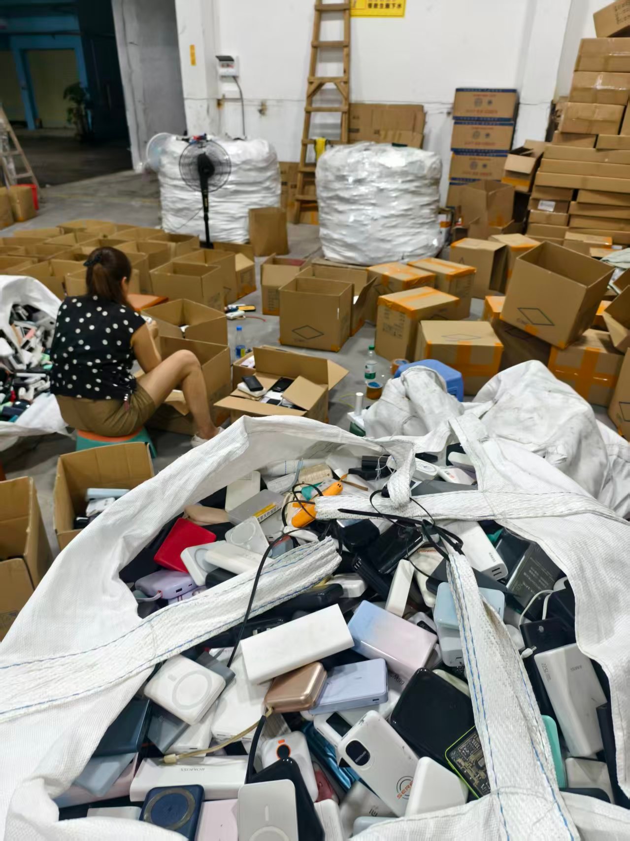Packing floor with used power banks and cartons during shipment preparation
