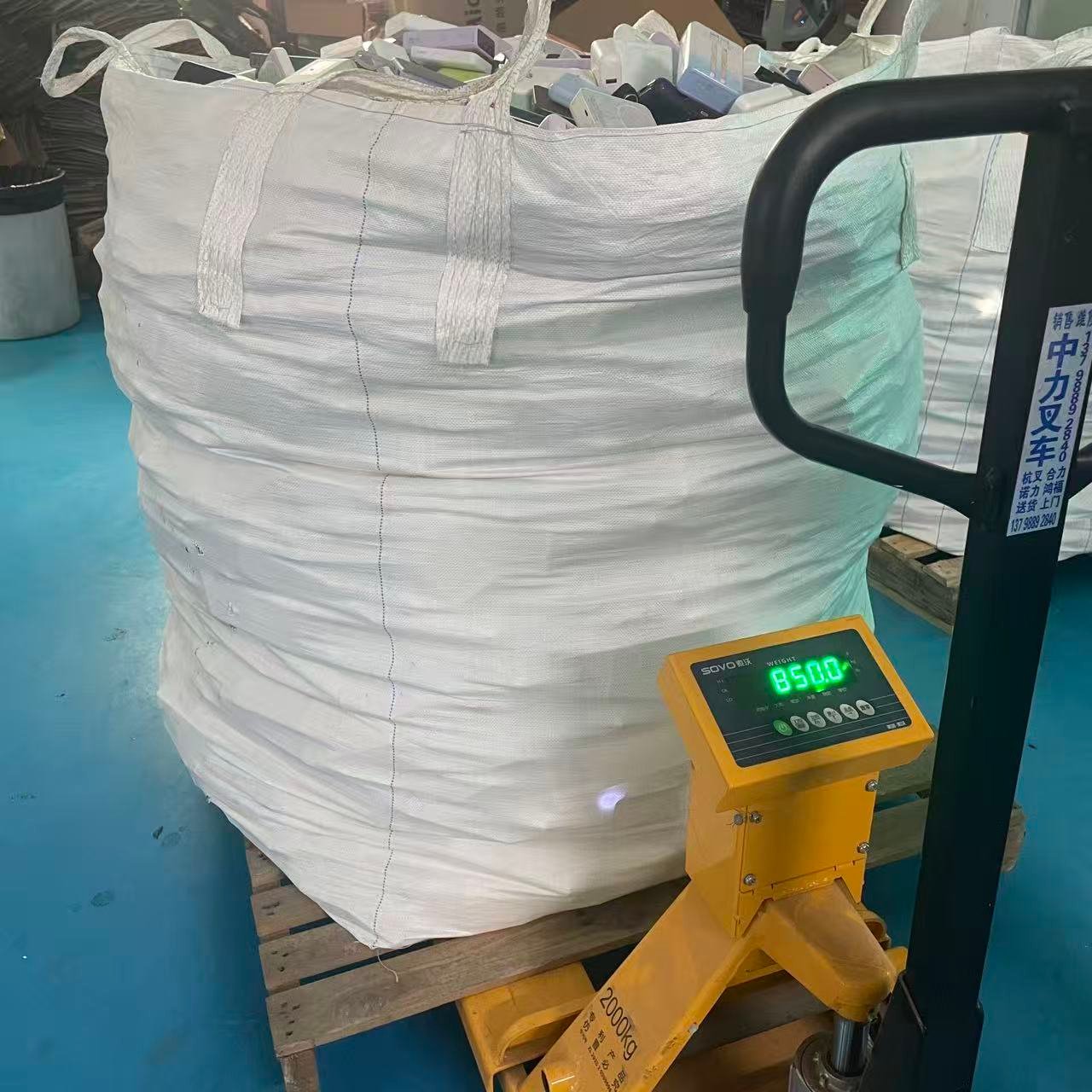 Bulk bag of used power banks in the warehouse on a pallet scale