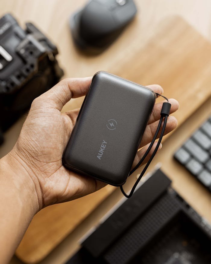 Person holding a sleek AUKEY power bank, ideal for tech and lifestyle themes.